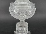 a clear glass bowl with a lid on a stand