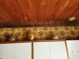 une cuisine avec un plafond en bois et un mur tapissé
