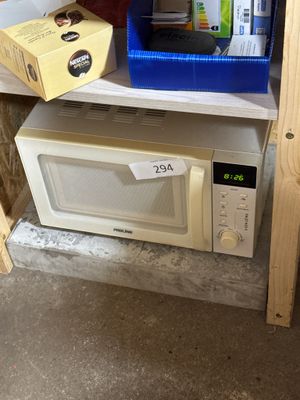 un micro-ondes posé sur une étagère dans une pièce