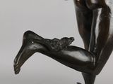 a bronze statue of a woman holding an umbrella on top of a ball