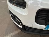 a close up of a white car with a blue tag on it