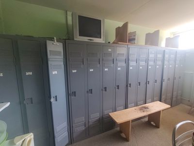 de nombreux casiers dans une pièce équipée d'un banc et d'un téléviseur