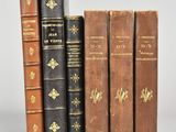plusieurs vieux livres sont alignés sur une surface blanche