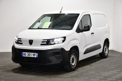 la camionnette blanche est garée dans une grande pièce au sol en damier