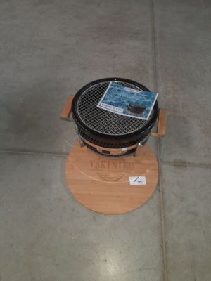 un petit barbecue posé sur un support en bois au sol