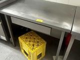 une caisse jaune placée sous un plan de travail en acier inoxydable dans une cuisine