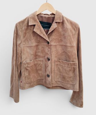 une veste en daim marron suspendue à un cintre