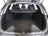 the back of a silver car with its trunk open and luggage in the trunk