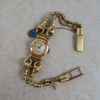 une montre en or et un briquet posés sur une table