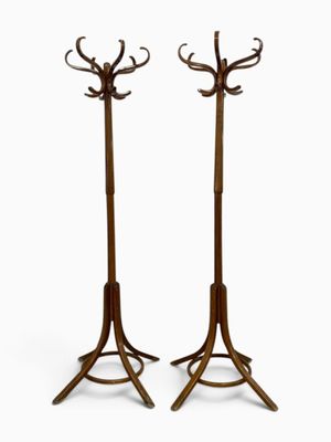 pair of tall wooden coat stands with deer heads on them