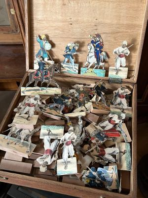 a wooden box filled with miniature figurines of people