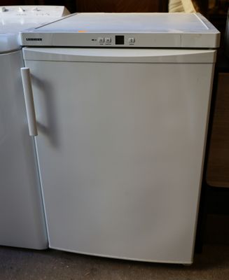 two white appliances sitting next to each other on the floor