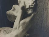 une vieille photo en noir et blanc représentant la sculpture d'un homme tenant un caillou
