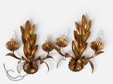 pair of gold leaf sconces on a white wall