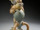 sculpture of a man carrying a fish on his back on a rock