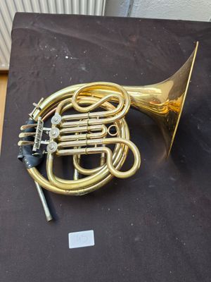 a brass instrument on a black cloth on a table