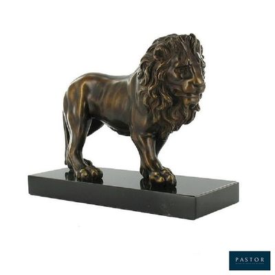 La statue d'un lion se dresse sur un socle noir.