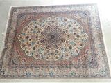 une photo d'un grand tapis oriental posé sur un sol blanc