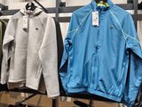 many jackets and pants hanging on a rack in a store