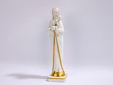 figurine représentant une femme avec une canne, vêtue d'une tenue blanche et dorée