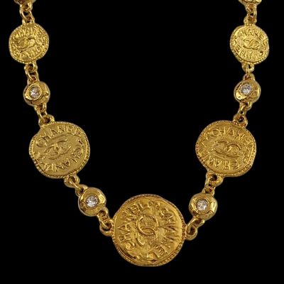 a close up of a gold necklace on a black background