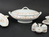 four pieces of white and orange china on a black table