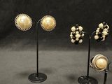 three pairs of earrings and a pair of earrings on a stand