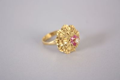 un gros plan d'une bague en or ornée d'une pierre rose au centre