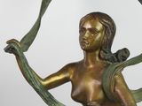 bronze statue of a woman holding a green ribbon in her hands
