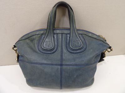 un sac à main bleu posé sur une table près d'un mur