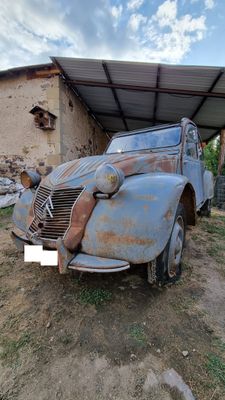 an old car that is sitting in the dirt