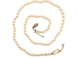 une photo d'un collier de perles blanches muni d'un fermoir en or