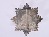 a silver brooch with a cross on it