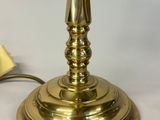 a gold candle that is sitting on a white table