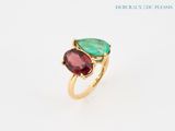 a close up of a gold ring with a green and red stone