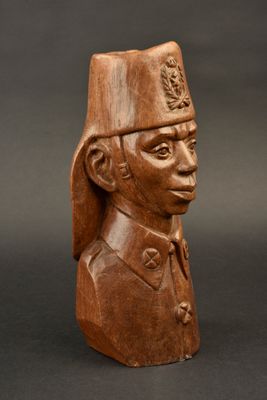 une busturine en bois représentant un homme coiffé d'un chapeau