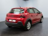 the rear of a red car is parked in a showroom