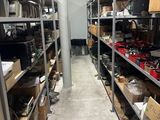 de nombreuses étagères sur lesquelles sont disposés divers objets dans la pièce