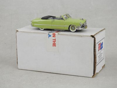 une petite voiture verte posée sur une boîte
