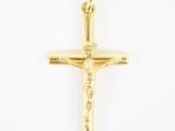 un pendentif en forme de croix en or jaune avec un crucifix sur fond blanc