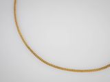 un collier à chaîne en or sur fond blanc