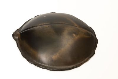 a metal object on a white surface with a white background