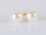 a pair of pearl earrings on a white surface