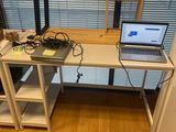 a laptop computer sitting on a desk in front of a window