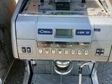 une machine à café posée par terre à côté d'une poubelle