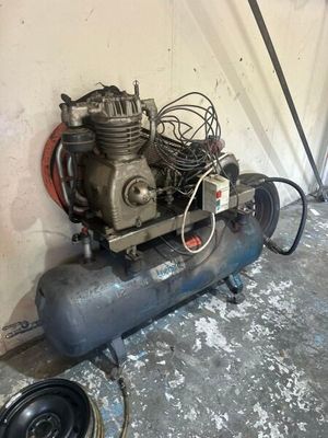 un petit compresseur d'air posé par terre dans un garage