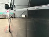 a black truck parked in a parking lot with other trucks in the background