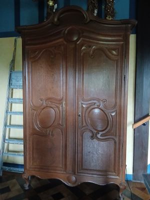 une grande armoire en bois dans le coin d'une pièce