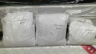 three bags of white yarn wrapped in plastic
