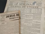 newspapers and a pen sitting on top of a table next to each other